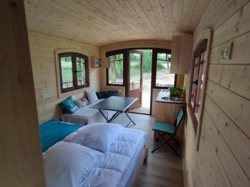 a living room of a tiny house with a couch and a table at Roulotte tout confort à la ferme in Saint-Lumine-de-Coutais