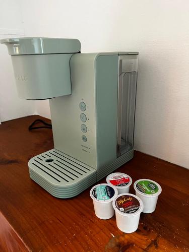 a coffee maker sitting on a table next to some cups at Air Vermont Apartment in South Burlington
