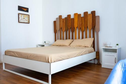 una camera da letto con un grande letto con testiera in legno di SUD 47 a Molfetta
