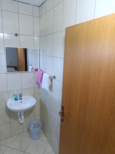 a bathroom with a sink and a mirror and a door at Guest House Robi in Međugorje