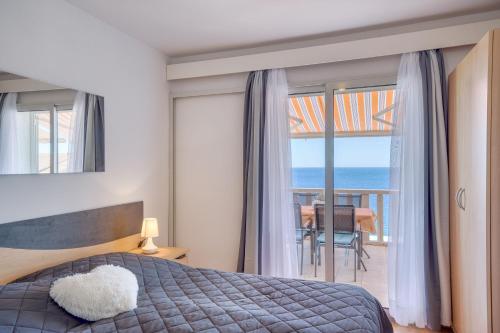 een slaapkamer met een bed en uitzicht op de oceaan bij Apartmani Marelic - Sun Beach in Zavalatica