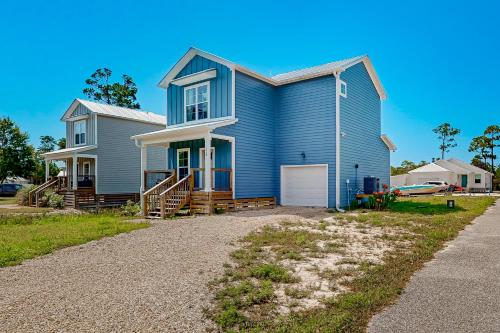 a blue house with a porch and a driveway at Lighthouse Cove in Carrabelle