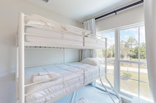 a bunk bed in a room with a window at Lighthouse Cove in Carrabelle
