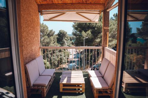 - une terrasse couverte avec 2 chaises et une table sur un balcon dans l'établissement Duplex de lumière vue sur la mer, à La Seyne-sur-Mer