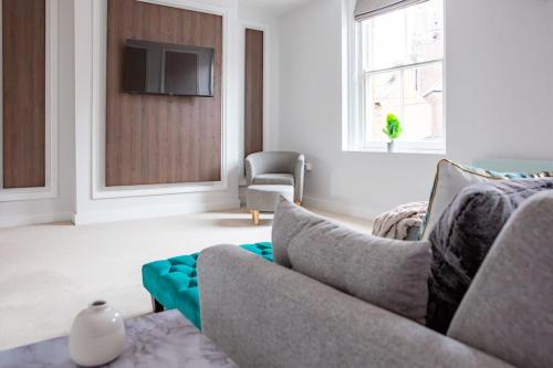 a living room with a couch and a tv at Quiet Luxury 2 Bed Apartment with Patio in Central Leicester in Leicester