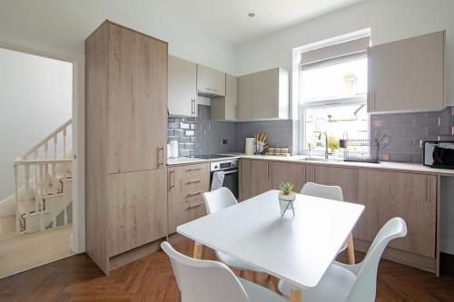 a kitchen with a white table and white chairs at Quiet Luxury 2 Bed Apartment with Patio in Central Leicester in Leicester