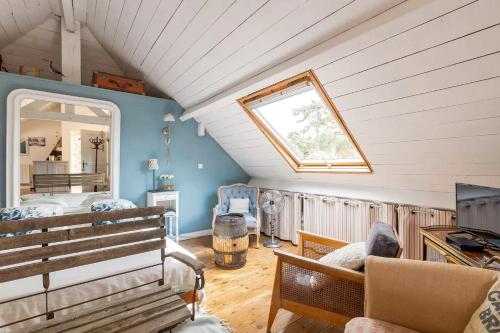 Cette chambre mansardée comprend un banc et une fenêtre. dans l'établissement Grande Chambre équipée dans maison Bauloise proche mer kitch sde wc lit 160, à La Baule