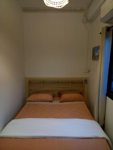 a bedroom with a bed with two pillows on it at Before We Go Hostel Donmueang in Ban Ko