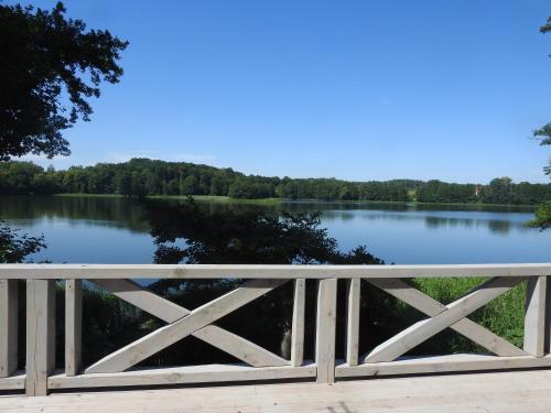 a bridge over a lake with trees in the background at Dom nad jeziorem in Sorkwity