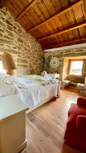 a bedroom with a bed and a stone wall at Casa Rural en Pontevedra in Sacos