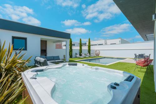 a hot tub in the backyard of a house at Villa Mauricio with jacuzzi and private swimming pool in Mariquiteira