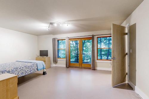 a bedroom with a bed and some windows at Muscongus Sound Lookout in Round Pond