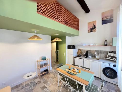 - une cuisine avec une table au milieu d'une pièce dans l'établissement Marseille soleil urbain, à Marseille