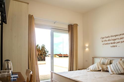 Il Soffione في كاستيلساردو: غرفة نوم بها سرير ونافذة كبيرة