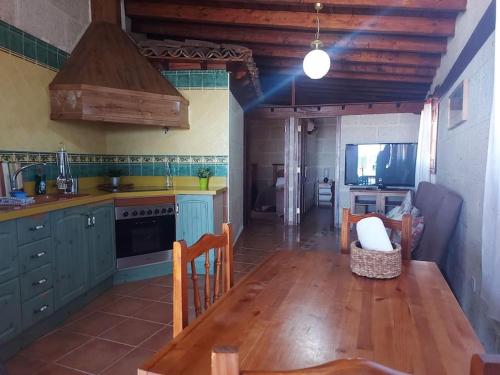 a kitchen with blue cabinets and a wooden table at Casa rural con piscina privada in Güimar