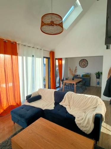 - une chambre avec un canapé bleu et une couverture dans l'établissement Maison familiale bord de mer, à La Turballe