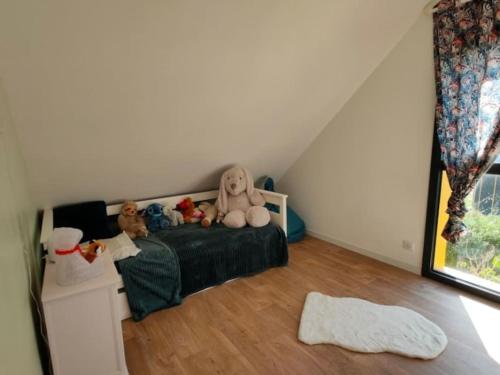 une chambre avec un lit avec des animaux en peluche dessus dans l'établissement Maison familiale bord de mer, à La Turballe