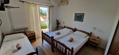 a bedroom with two beds and a window at Palute in Supetar