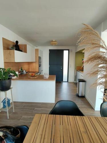 un salon avec une table et une cuisine dans l'établissement Maison familiale bord de mer, à La Turballe