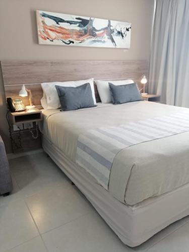 a bedroom with a large white bed with blue pillows at Inizio Hotel in San Francisco
