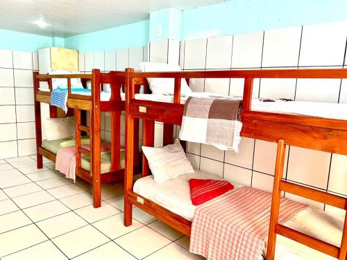a room with three bunk beds and a bed at A Casa dos Mestres in Salvador