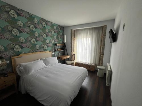 a bedroom with a white bed and a green wall at Christine Boutique Hotel in El Barraco