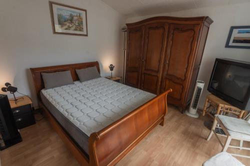 - une chambre avec un lit, une commode et une télévision dans l'établissement Appartement Confort 57 m2 avec terrasse parking couvert, au Cap d'Agde