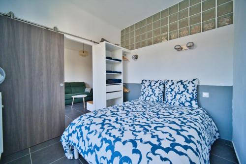 une chambre avec un lit avec une couette bleue et blanche dans l'établissement oliveraie, à Nice