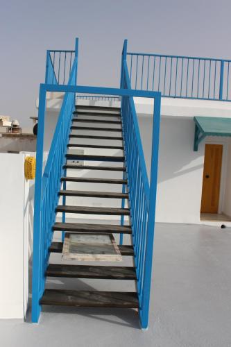 a staircase with blue railings on a white building at Hôtel Medina in Sousse