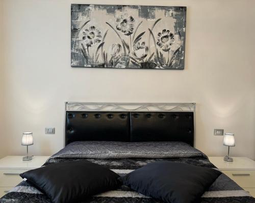a bedroom with a black bed with two lamps at Family Stylish Apartment in Norcia