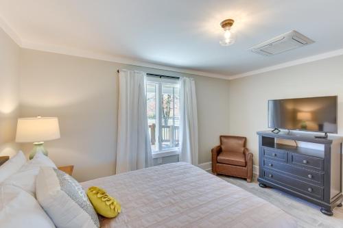 a bedroom with a bed and a television and a chair at Modern Clarkesville Cottage with Decks and Patio! in Lakemont