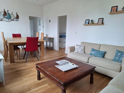 a living room with a couch and a table at Appartement au cœur de la Côte de Granit Rose. in Trégastel