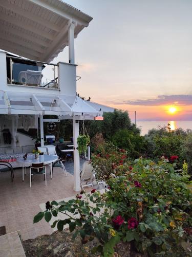 a house with a balcony with a sunset in the background at Villa Panorama, now a Smart Home in Skala Kallirakhis