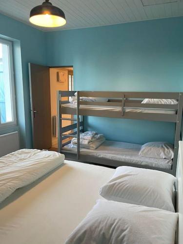 Cette chambre comprend 2 lits superposés et un mur bleu. dans l'établissement LES CRISTELLES, à Beauvoir-sur-Mer