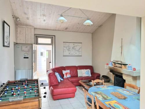 un salon avec un canapé rouge et une table dans l'établissement LES CRISTELLES, à Beauvoir-sur-Mer