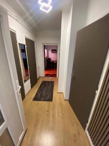 an empty room with a hallway with a door and a rug at CENTRUM Apartman in Sárospatak