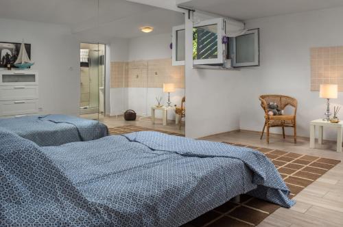 two beds in a bedroom with blue blankets at Modern Villa Krk in Gabonjin