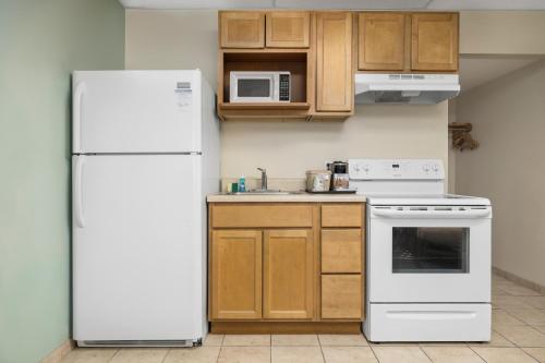 a kitchen with a white refrigerator and wooden cabinets at Beachside Resort Panama City Beach in Panama City Beach