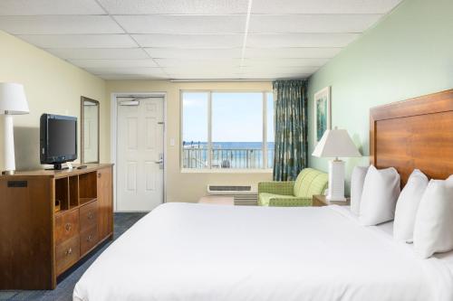 a hotel room with a bed and a television at Beachside Resort Panama City Beach in Panama City Beach