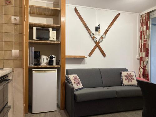 - un salon avec un canapé et un four micro-ondes dans l'établissement Chez papi fernand la montagnette, aux Menuires