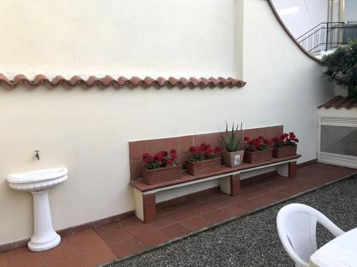 a bench with flowers on it next to a wall at La casina - Castiglioncello in Castiglioncello