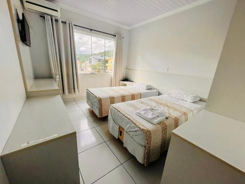 a hotel room with two beds and a window at Hotel Dell Grappa in Nova Bassano