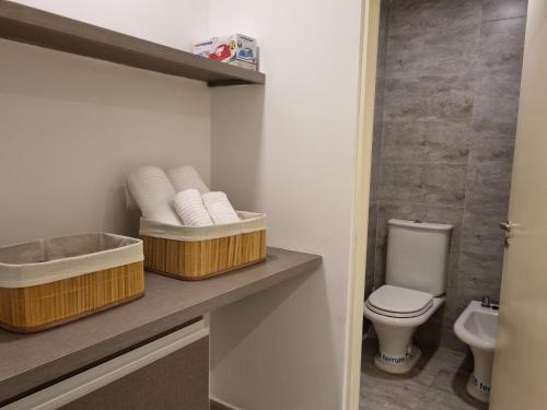 Un baño con dos cestas de toallas y un inodoro. en Balcarce Confort Apart 1C, en Salta