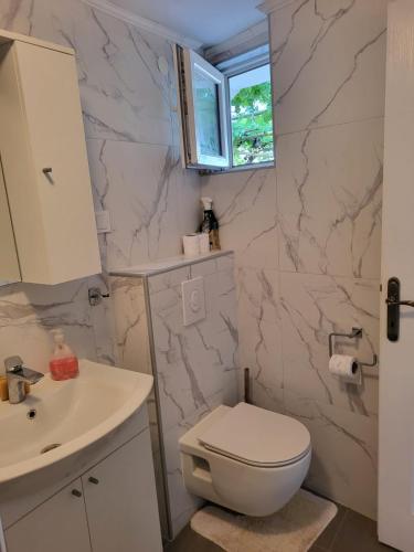 a bathroom with a white toilet and a sink at Guesthouse Gravosa in Dubrovnik