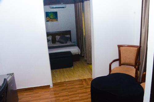 a room with a bed and a chair and a mirror at J Gibson suite in Lekki