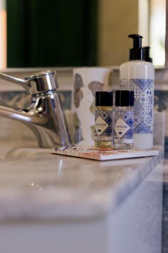 a bathroom sink with two bottles of soap and a mirror at Quinta da Falfeira in Lagos