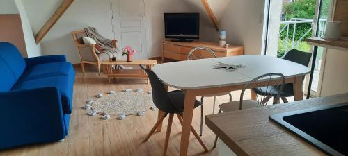 un salon avec une table et des chaises blanches dans l'établissement Au sable de l'estran, à Cucq