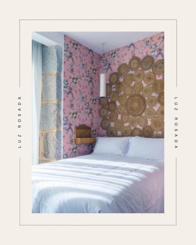 a bedroom with a bed with a wall covered in logs at Christine Boutique Hotel in El Barraco