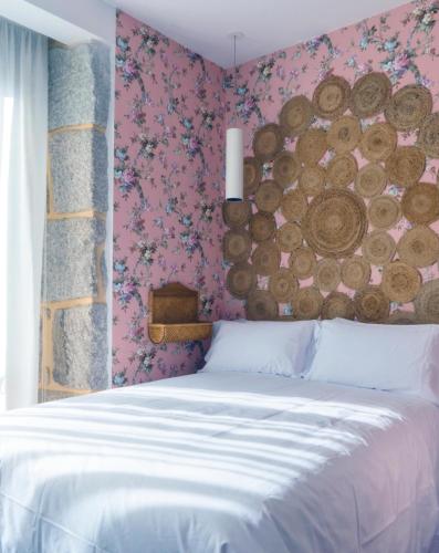 a bedroom with a bed with a wall covered in logs at Christine Boutique Hotel in El Barraco