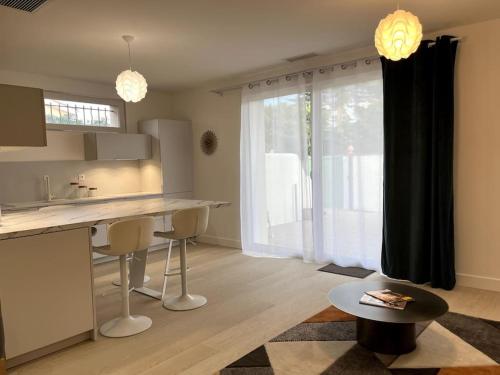 a kitchen with a counter and a table and a window at La Villa du Soleil in Saint-Cyprien